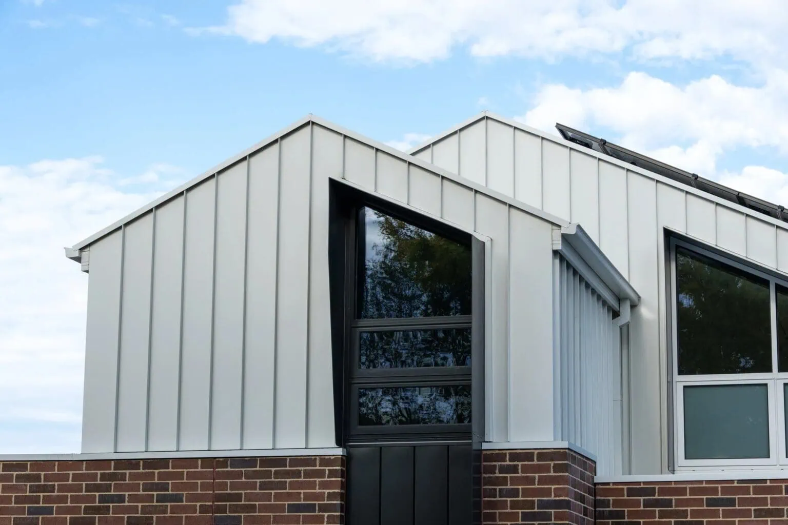 Standing-seam metal cladding and angular black-framed windows on a Melbourne home extension by Quickset Carpentry