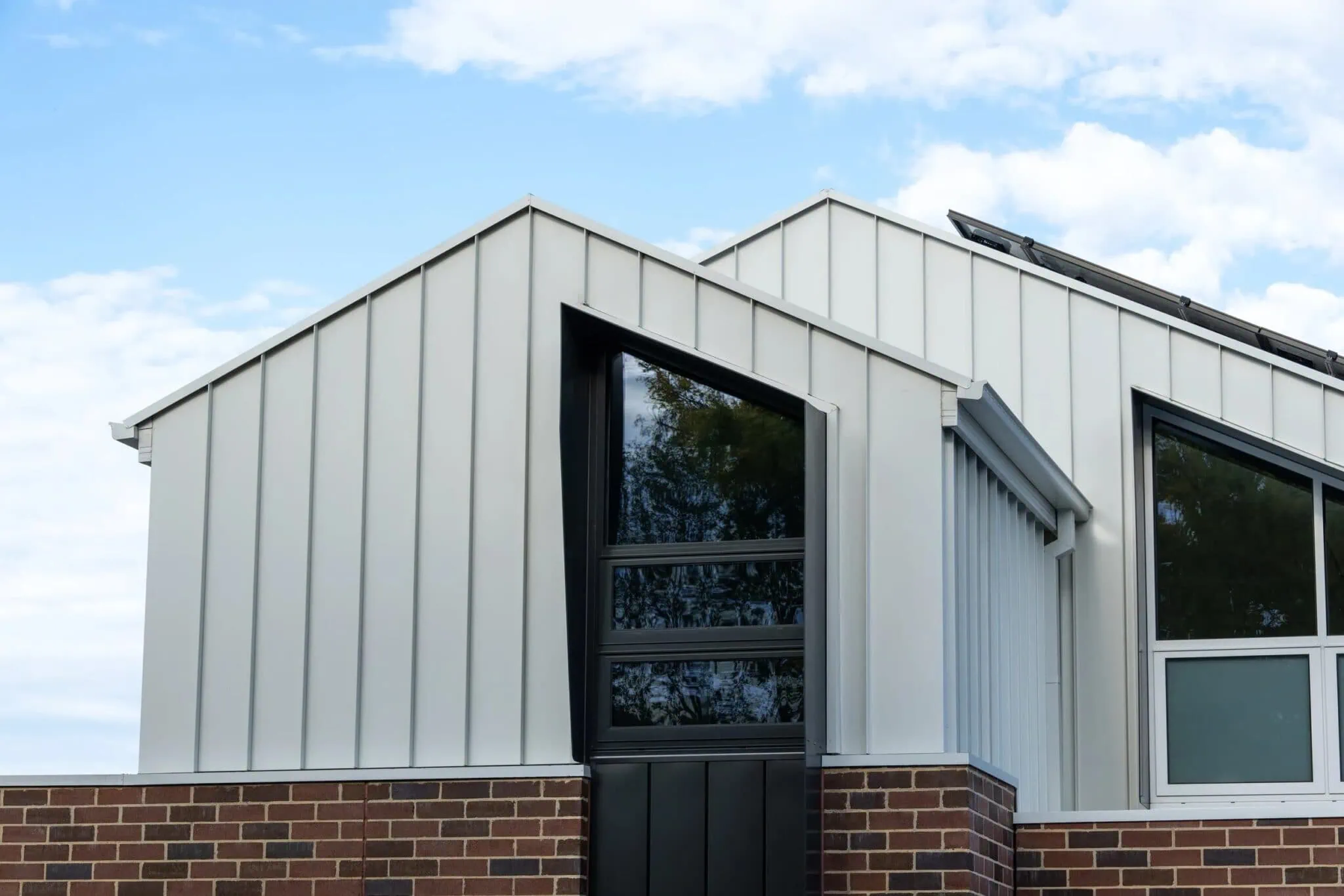 Standing-seam metal cladding and angular black-framed windows on a Melbourne home extension by Quickset Carpentry